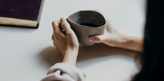 Two people at a table with a teacup