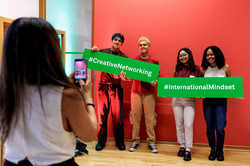 A photo is being taken of four people holding two signs