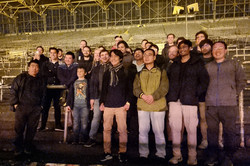 Menschen stehen auf der Tribüne eines Fußballstadions