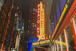 Boston Hier sieht man zahlreiche beleuchtete Hochhäuser bei Nacht, die mit Leuchtschrift dekoriert sind, auf der "French Quarter" steht.