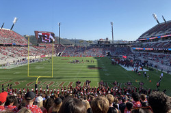 SDSU Football Ein Footballstadion mit grünem Rasen und voll besetzer Tribüne rund um den Rasen. Man erkennt einen großen Bildschirm in der Ecke des Spielfeldes.