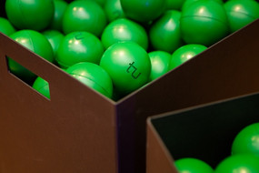 Eine Kiste gefüllt mit grünen TU Stressbällen