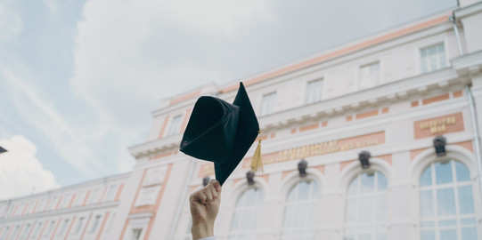 Graduation Cap  being held in the air