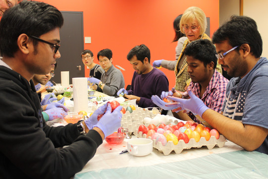 indian, chinese, male students painting easter eggs