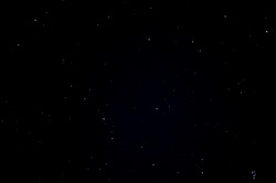 Hier sieht man das kugelförmige Observatorium mit einem sternenklaren Himmel bei Nacht im Hintergrund. 