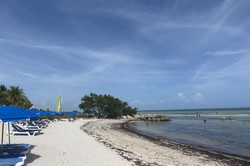 Es zeigt den weißen Strand in Key West, das flache Wasser und den blauen Himmel
