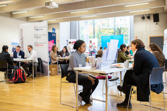 Lots of tables in a large room where people are having conversations