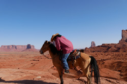 Monument Valley Eine Person steigt von einem Pferd ab.