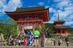 Drei Studierende der TU Dortmund in Kyoto. Von links nach rechts stehen in der Mitte des Bildes: Lisa, Yannik und Dagny. Lisa und Dagny tragen Yukata, traditionell japanische Kleidung. Yannik trägt die TU Dortmund-Flagge.