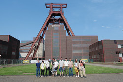 A group of people in front of the shaft tower at Zeche Zollverein. 