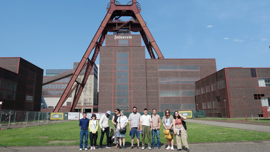 A group of people in front of the shaft tower at Zeche Zollverein.