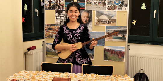 Eine Gitarre spielende Asiatin beim Internationalen KulturCafé (IKC)