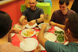 Eine Gruppe internationaler Studierender, die zusammen asiatisch Essen mit Stäbchen im Internationalen Begegnungszentrum (IBZ)