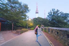 Ina-Marie im Park mit einem Fernsehturm (Namsam) im Hintergrund