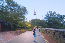 Ina-Marie im Park mit einem Fernsehturm (Namsam) im Hintergrund