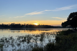 Hier sieht man einen Sonnenuntergang am See.