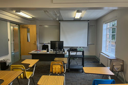 Klassenräume Hier sieht man einen Klassenraum bestehend aus Holztischen und -stühlen.