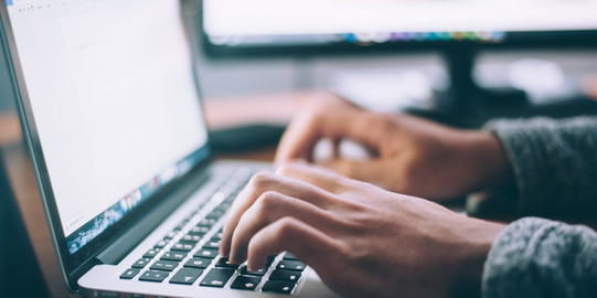 Bewerbung Person schreibt am Laptop