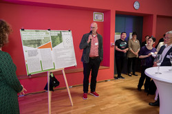A Global Gallery project exhibitor stands next to his project and presents it to the participants of the Global Gallery