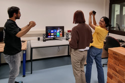 Menschen stehen jubelnd vor einem Bildschirm mit Videospiel.