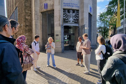 A group of people is standing in front of a museum. 