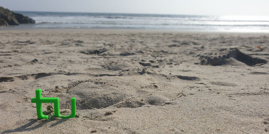 Das TU Logo im Sand des Strandes Kalifornien