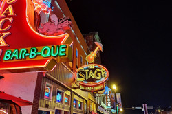 Nashville Hier sieht man eine beleuchtete Straße voller Bars und Neonschilder.