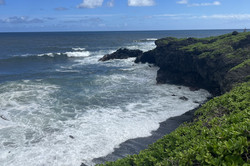 Bucht in Kipahulu, Maui Hier sieht man eine Bucht. Das Wasser bricht gerade an den Felsen und der Himmel ist blau.