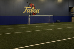 Ein Fußballtor in einer Halle, an der Wand befindet sich das Logo mit der Aufschrift Tulsa 