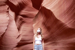 Antelope Canyon Eine Person steht vor einem rötlichen Gestein.