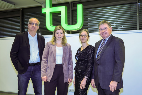 Gruppenfoto vor dem TU Logo mit dem Rektor Rektor Prof. Manfred Bayer, Preisträgerin Dr. Marion Börnhorst, Prorektorin Forschung Prof. Nele McElvany und Dr. Gert Fischer, Vorstandsmitglied der Rudolf Chaudoire-Stiftung. 