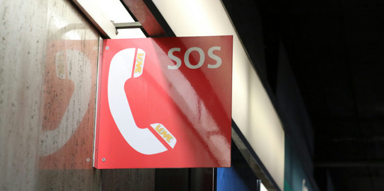 A red and white SOS sign
