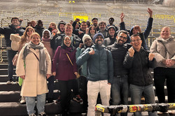 Menschen stehen jubelnd auf der Tribüne eines Fußballstadions