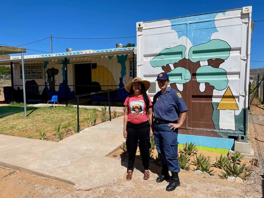 2 Personen stehen vor einem bunt gemalten Gebäude