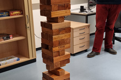 Ein großer Jenga-Turm und eine Person im Hintergrund
