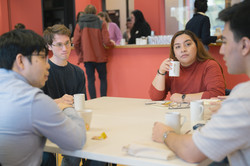 4 internationale Studierende unterhalten sich mit einem Kaffee am Tisch