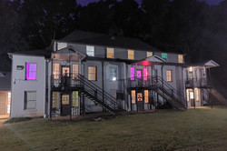 Hier sieht man ein Wohnheim bei Nacht, das bunt beleuchtet und dekoriert ist.