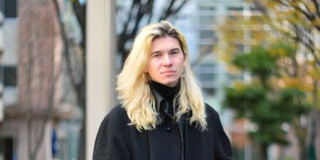 Picture of Matthis on the campus with tress with autumn colors 