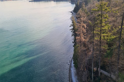 Hier sieht man das Meer und einen angrenzenden Park. Das Meer ist türkis und dunkelblau.