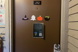 Tür Hier sjeht man die Tür zum Wohnheimzimmer und die Namen sind auf kleinen Halloween Schildern.