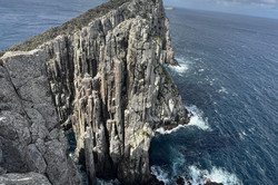 Cape Hauy Hier sieht man eine steile Klippe am Wasser.