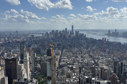 Es zeigt die Skyline von New York vom Empire State Building, der Himmel ist blaue mit vereinzelnen Wolken