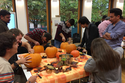Eine Gruppe internationaler Studierender, die für Halloween Kürbisse schnitzen im Internationalen Begegnungszentrum (IBZ)