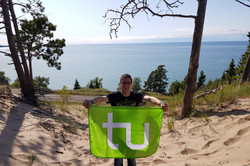 Daniel mit der TU Flagge mit dem Pazifik im Hintergrund.