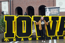 Samira vor dem Iowa Hawkeyes Logo