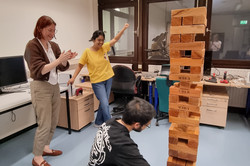 Menschen stehen um einen großen Jenga-Turm.