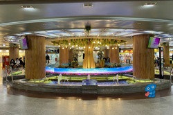 Untergrund Mall Hier sieht man eine unterirdische Shopping Mall. Man sieht ein Springbrunnen, in dem ein Baum integriert ist und der bunt angestrahlt wird.