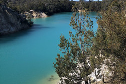 Little Blue Lake Hier sieht man einen Strand an einem Gebirge mit türkisblauem Wasser.