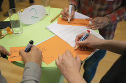 Midterm Meeting Tandem2Job 2024 Focus on the hands of three people writing cards