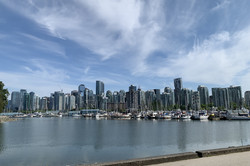 Hier sieht man die Skyline von Vancouver. Man sieht Wasser und viele Hochhäuser.